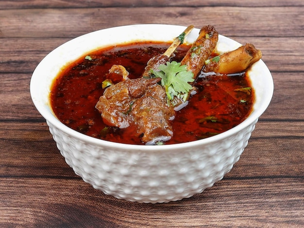 Foto mutton masala ou lamb masala prato picante e delicioso servido sobre um foco seletivo de fundo de madeira rústica