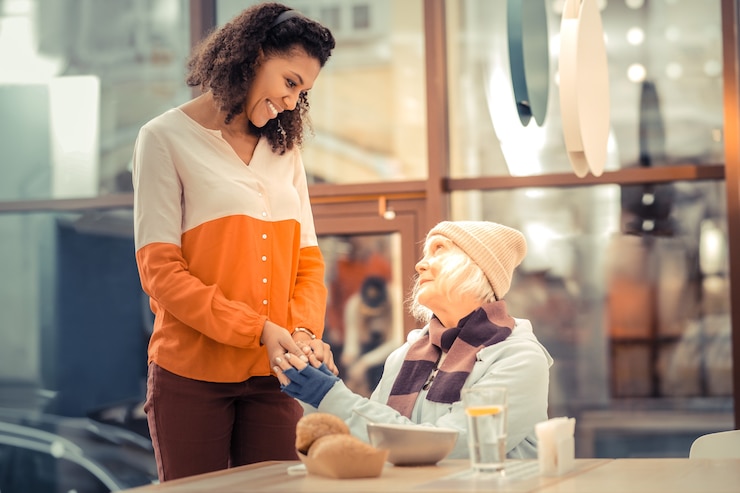 Foto muy agradecido. bonita mujer de edad mirando a la joven mientras está llena de gratitud hacia ella