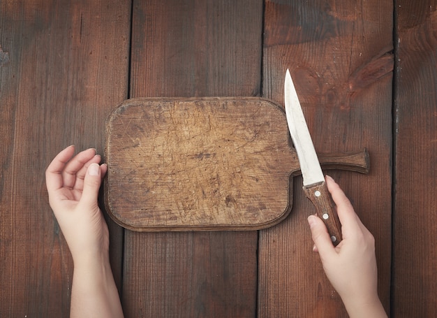 Muy antigua tabla de cortar rectangular de madera vacía y un cuchillo afilado