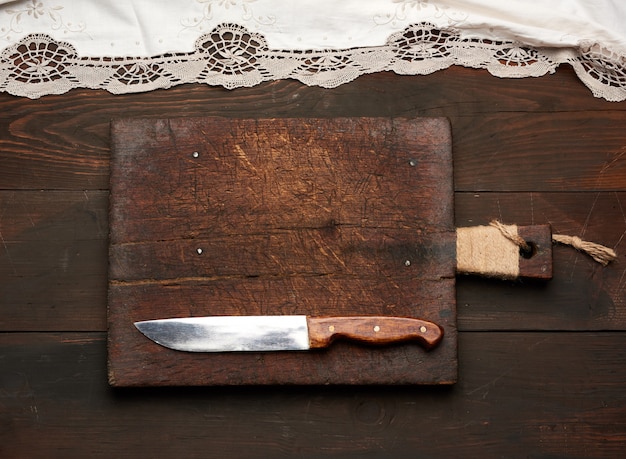 Muy antigua tabla de cortar rectangular de madera vacía y cuchillo