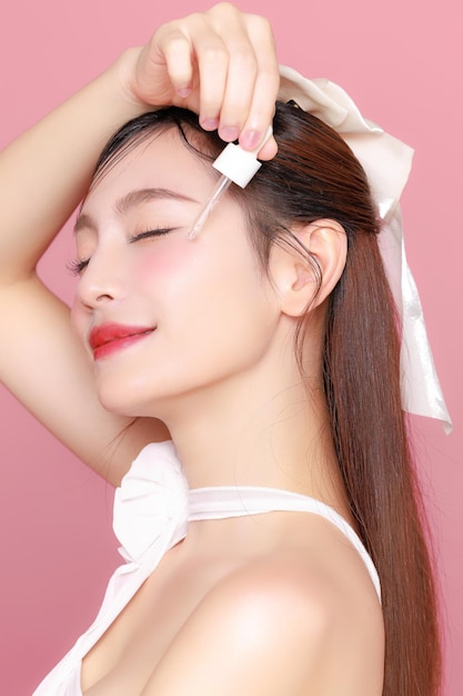 Muy bonita mujer asiática modelo de cabello largo perfecta piel clara y fresca sonrisa en fondo rosa aislado retrato elegante blogger de belleza mujer maquillaje artista en estudio cuidado de la piel concepto de cirugía plástica spa