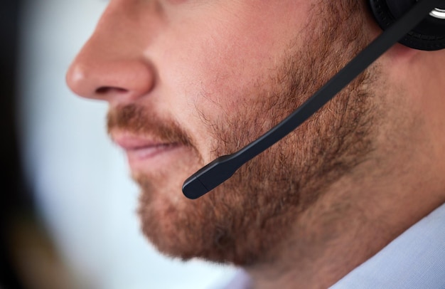 Una muy buena atención al cliente Foto de un hombre irreconocible usando un auricular en una oficina moderna