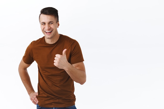 Muy buena elección, impresionante. Apuesto hombre adulto sonriente, feliz en camiseta marrón, riendo satisfecho