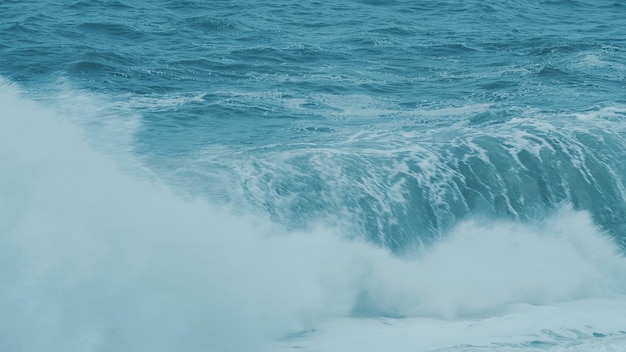 Muy gran ola salpicando la orilla del océano rompe en vista delantera mar tormentoso con grandes olas azules grandes