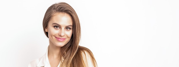 Muy sonriente hermosa mujer con cabello oscuro, vestida con una camisa blanca, mirando a cámara aislada contra el fondo blanco con espacio de copia