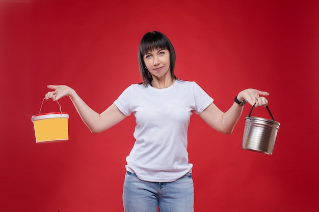 Muy sonriente mujer sosteniendo pinturas en manos