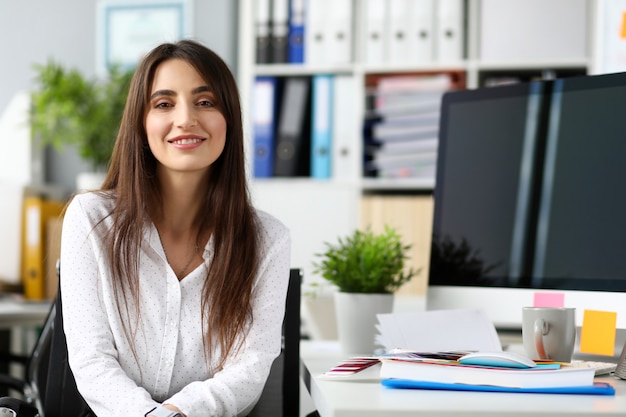 Foto muy sonriente pm o empleado sentado en la mesa de trabajo