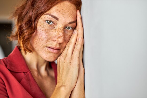 mysteriöse Frau mit den roten Haaren, die Kamera betrachten, junge Dame mit natürlicher Schönheit, die Piercing hat