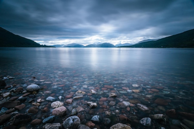 Mystische Landschaft Seelandschaft in Schottland Bewölkter Himmel Sonnenstrahlen und Bergkette in Loch Linnhe