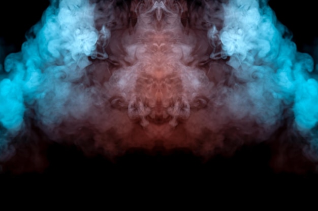 Mystisches Muster aus grün-blauem und rosafarbenem Rauch in Form eines Geistergesichts mit großen Augen und offenem Mund, das ein Gefühl der Angst auf einem schwarzen, isolierten Hintergrund aus einem Horrorfilm erzeugt