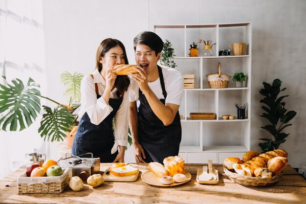 Na cozinha Casal perfeitamente feliz Preparando comida saudável Muitos vegetais Homem Faz malabarismo com frutas Faz a namorada rir Pessoas adoráveis se divertem