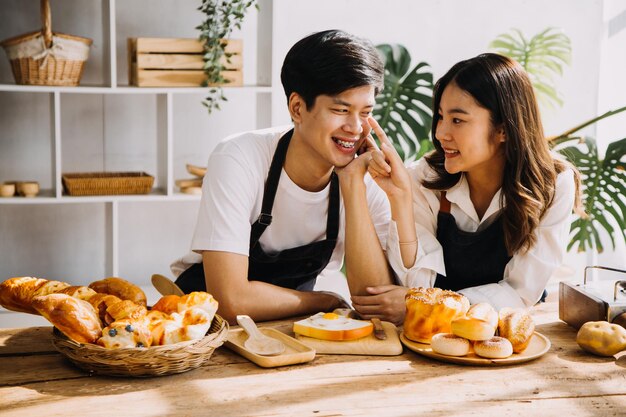 Na cozinha Casal perfeitamente feliz Preparando comida saudável Muitos vegetais Homem Faz malabarismo com frutas Faz a namorada rir Pessoas adoráveis se divertem