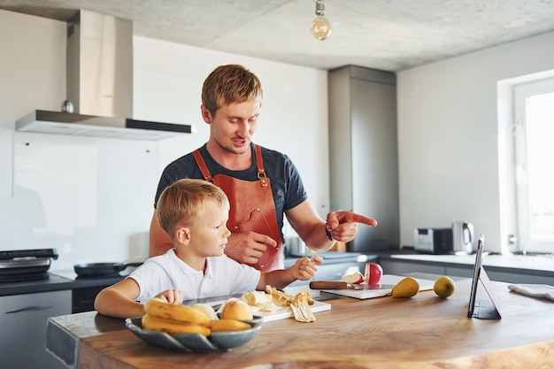 Na cozinha com comida Pai e filho estão dentro de casa juntos