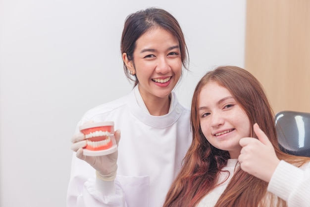 Na mandíbula artificial, o médico demonstra claramente como escovar os dentes do paciente com uma escova de dente.