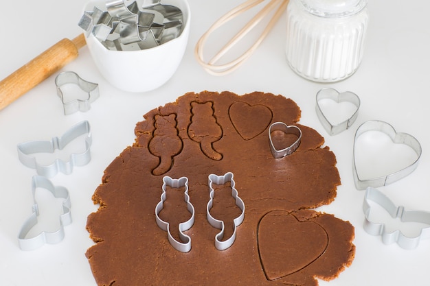 Na mesa da cozinha enrolada massa de gengibre, cortadores de biscoito em forma de gatos - dia mundial do gato