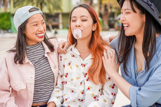 Na moda asiáticas meninas se divertindo juntos ao ar livre