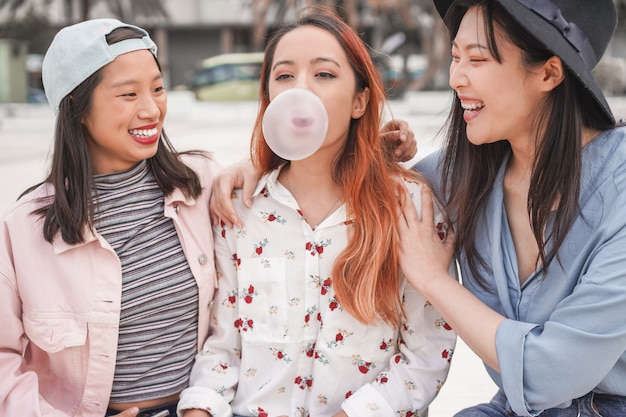 Na moda asiáticas meninas se divertindo juntos ao ar livre