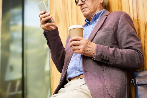 Foto na moda homem sênior usando smartphone