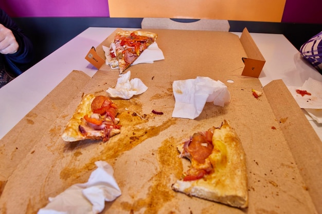 Foto nach dem mittagessen liegen halb aufgegessene pizzastücke auf dem tisch