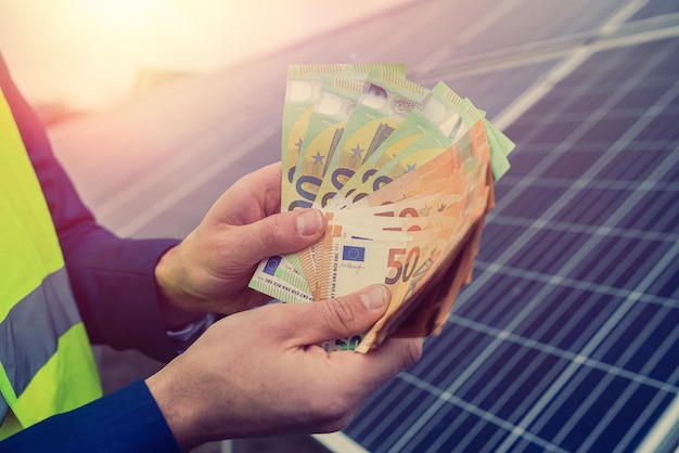 Nach der Installation sparsamer Sonnenkollektoren zahlt der Eigentümer des Projekts in Euro. Das Konzept der grünen Energieeinsparung