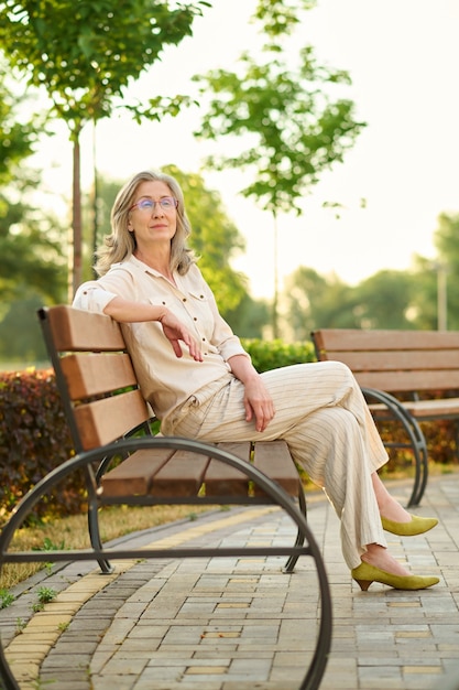 Nachdenkliche Frau auf der Parkbank am Nachmittag