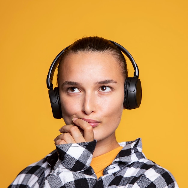 Foto nachdenkliche frau, die musik über kopfhörer hört