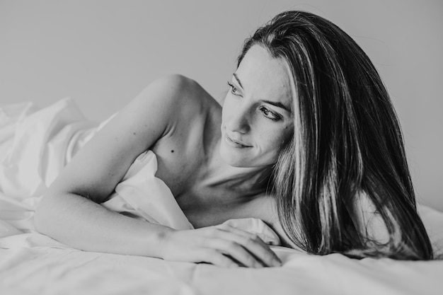 Nachdenkliche Frau liegt auf dem Bett