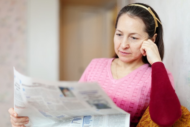 Foto nachdenkliche frau liest zeitung