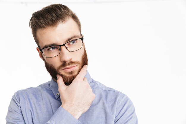 Foto nachdenklicher bärtiger, eleganter mann mit brille, der sein kinn hält und wegschaut