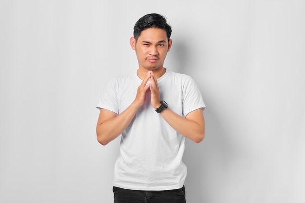 Nachdenklicher junger asiatischer Mann mit ernstem Gesicht, der über eine Frage nachdenkt, nachdenklich über verwirrende Ideen isoliert auf weißem Hintergrund