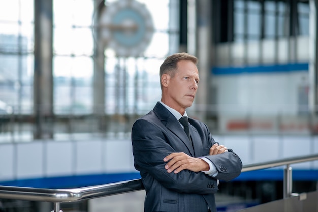 Nachdenklicher Mann im Anzug wartet am Flughafen