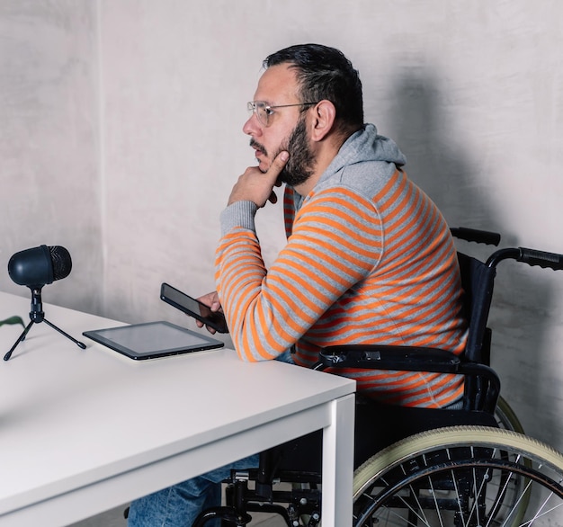 nachdenklicher Mann im Rollstuhl mit Brille