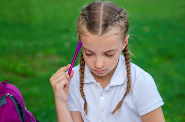 Foto nachdenkliches auflösungsproblem des kleinen mädchens für test. schulschüler lernen zur prüfung