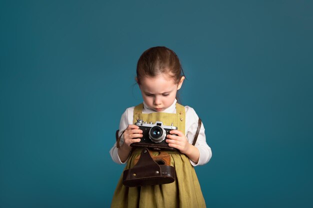 Nachdenkliches ernstes kleines Mädchen beabsichtigt, das Fotografieren zu lernen