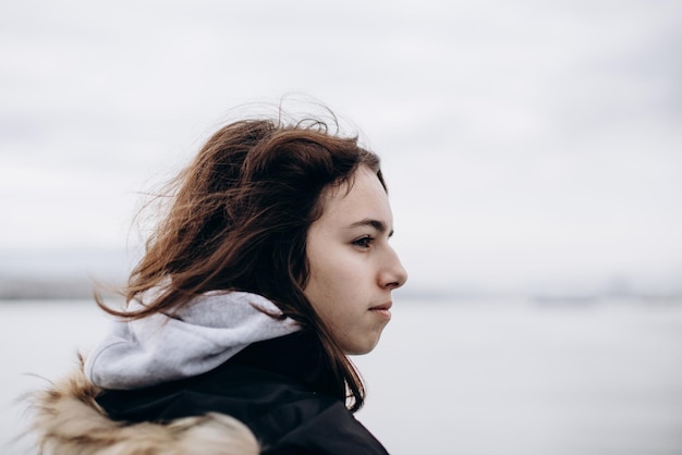 Nachdenkliches junges Mädchen mit Blick auf das Meer vom Boot Teenager-Mädchen auf der Fähre Kaltes graues Meer