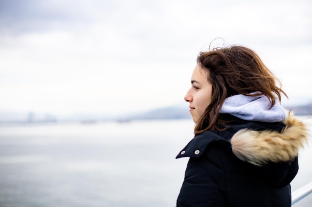 Nachdenkliches junges Mädchen mit Blick auf das Meer vom Boot Teenager-Mädchen auf der Fähre Kaltes graues Meer