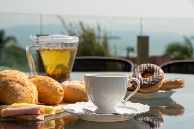 Nachmittagstee serviert auf einem gedeckten Tisch, Nachmittagskaffee, Croissant, Käsebrot, verschiedene Speisen