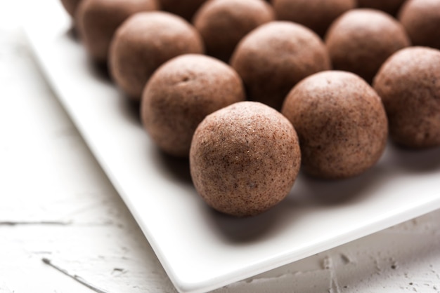 Nachni laddu o Ragi laddoo o bolas hechas con mijo, azúcar y ghee. Es un alimento saludable de la India. Servido en un bol o plato con crudo entero y en polvo. Enfoque selectivo