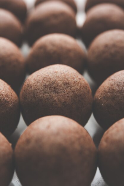 Nachni laddu ou ragi laddoo ou bolas feitas de milho, açúcar e ghee. é um alimento saudável da índia. servido em uma tigela ou prato com todo cru e pó. foco seletivo