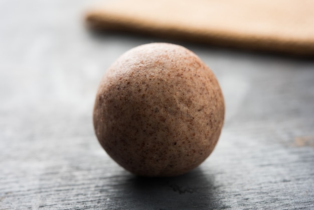 Nachni laddu ou ragi laddoo ou bolas feitas de milho, açúcar e ghee. é um alimento saudável da índia. servido em uma tigela ou prato com todo cru e pó. foco seletivo