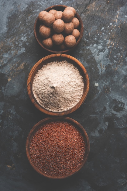 Nachni laddu ou Ragi laddoo ou bolas feitas de milho, açúcar e ghee. É um alimento saudável da Índia. Servido em uma tigela ou prato com todo cru e pó. Foco seletivo