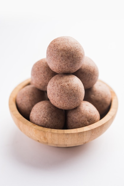 Nachni laddu ou Ragi laddoo ou bolas feitas de milho, açúcar e ghee. É um alimento saudável da Índia. Servido em uma tigela ou prato com todo cru e pó. Foco seletivo