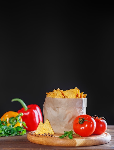 Nacho chips no pacote com salsa e tomate