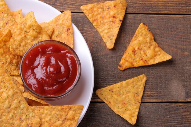 Nachos auf einem weißen Teller mit roter Sauce