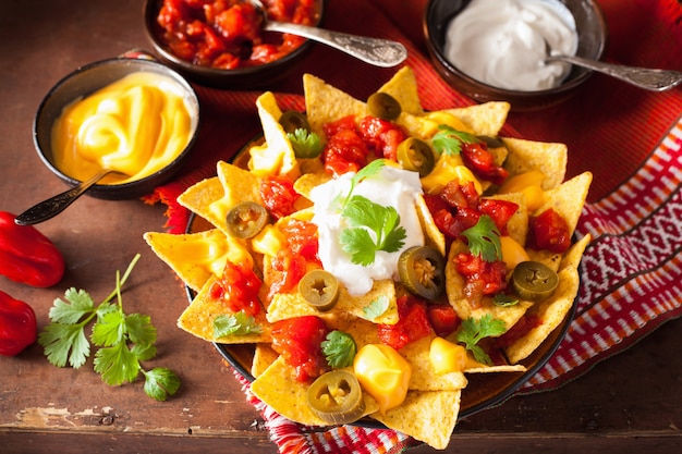 Nachos beladen mit Salsa, Käse und Jalapeno