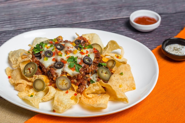 Nachos de carne molida picante de comida mexicana famosa Tortillas crujientes calentadas con queso derretido y jalapeño servidos como bocadillos