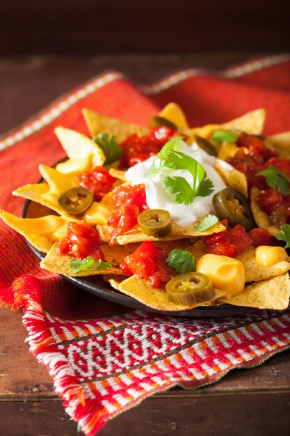 Foto nachos carregados com salsa, queijo e jalapeno