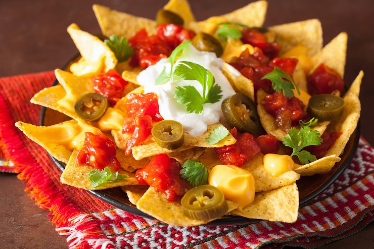 Foto nachos carregados com salsa, queijo e jalapeno