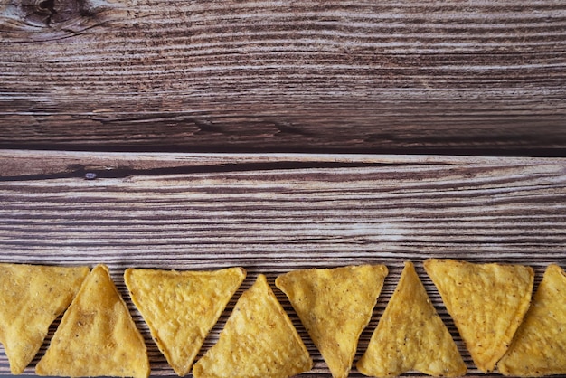 Nachos chips de milho em um fundo de madeira com espaço para texto cozinha mexicana