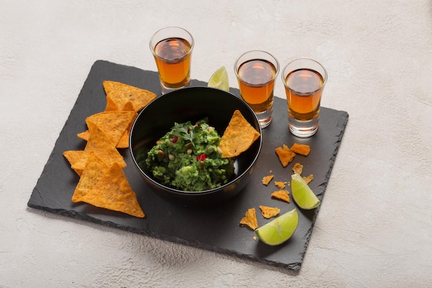 Nachos chips con guacamole y tragos de whisky o tequila oscuro